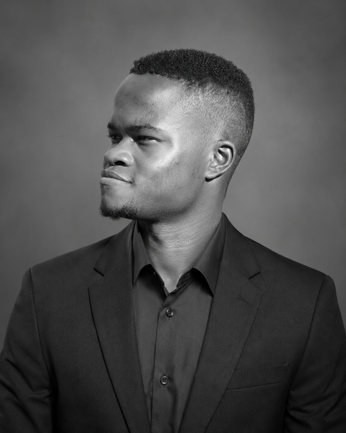 Leo Mabuku wearing a dark suit in a black-and-white portrait
